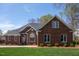 Charming brick home with well-manicured lawn, mature trees, and classic architectural details at 805 Lee St, Gibsonville, NC 27249
