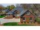 Beautiful brick home featuring mature landscaping, an arched entryway, and a two-car garage at 805 Lee St, Gibsonville, NC 27249