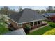 Aerial view of the rear exterior with a brick facade, covered porch, and well-maintained landscaping at 805 Lee St, Gibsonville, NC 27249