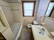 Bright bathroom features a tiled shower-tub, vanity with sink, and mosaic-tiled floor at 807 Everett St, Burlington, NC 27215
