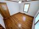 Bedroom features hardwood floors, a window with blinds, and a wood-paneled door at 807 Everett St, Burlington, NC 27215