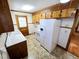 Cozy kitchen with white appliances, wood cabinets, and a white countertop at 807 Everett St, Burlington, NC 27215