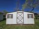 Outdoor shed with a white exterior, brown trim, and windows, providing extra storage space at 807 Everett St, Burlington, NC 27215