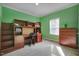 Bright bedroom featuring green walls, built-in desk with stairs, and a chest of drawers at 90 Ferncrest Ct, Roxboro, NC 27574