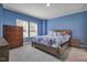 Comfortable bedroom features bright blue walls, carpet flooring, and a bright window with natural light at 90 Ferncrest Ct, Roxboro, NC 27574