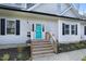 Welcoming front porch features stairs, flowers, and a vibrant blue door with sidelights and stone walkway at 90 Ferncrest Ct, Roxboro, NC 27574