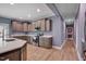 View of a bright kitchen with custom cabinets, stainless steel appliances, stone countertops and hardwood floors at 90 Ferncrest Ct, Roxboro, NC 27574