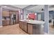 Bright kitchen boasts stainless steel appliances, an island with marble countertop, and modern wood flooring at 90 Ferncrest Ct, Roxboro, NC 27574
