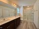 Bathroom boasts double sinks, wood-look flooring, a large mirror, and a glass-enclosed shower at 93 Steel Springs Ln, Angier, NC 27501