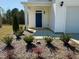 Close-up view of the front porch featuring a dark blue front door and landscaping at 93 Steel Springs Ln, Angier, NC 27501