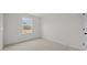 Bedroom features neutral carpet, white walls, and a large window with an outdoor view at 1009 Shovelhead Dr # 5, Durham, NC 27703