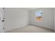 Bright bedroom features a neutral carpet, white walls, and natural light from the window at 1009 Shovelhead Dr # 5, Durham, NC 27703