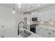 Well-lit kitchen with an island, stainless steel sink, and sleek black gas range at 1009 Shovelhead Dr # 5, Durham, NC 27703