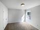 A carpeted bedroom with white walls, one window and white doors at 106 Canvasback Dr, Durham, NC 27704