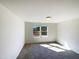 A bright, carpeted bedroom featuring a large window bringing in plenty of natural light at 106 Canvasback Dr, Durham, NC 27704