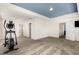 Large, carpeted bonus room with ample space, blue accent ceiling, and multiple doorways at 110 White Burley Ct, Durham, NC 27703
