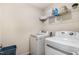Convenient laundry room equipped with modern washer and dryer units and storage shelves at 110 White Burley Ct, Durham, NC 27703