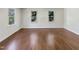 Spacious bedroom with gleaming hardwood floors, three windows allowing natural light to fill the space at 112 Old Bridge Ln, Chapel Hill, NC 27517