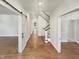 Bright hallway featuring hardwood floors, staircase, and opening to other rooms in the house at 112 Old Bridge Ln, Chapel Hill, NC 27517