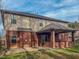 The back of the home with a covered patio, brick facade and siding on the second level at 1171 Jackson Ct, Creedmoor, NC 27522