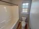 This well-lit bathroom features a clean white tub/shower combo and wood-look flooring at 1171 Jackson Ct, Creedmoor, NC 27522