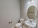 Clean and simple powder room featuring a pedestal sink, round mirror, and white fixtures at 1171 Jackson Ct, Creedmoor, NC 27522