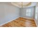 Dining room featuring a tray ceiling, modern chandelier, and wood-look floors at 1171 Jackson Ct, Creedmoor, NC 27522