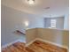 Upstairs hallway with wood-look flooring, neutral walls, and a charming light fixture at 1171 Jackson Ct, Creedmoor, NC 27522