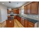 Well-equipped kitchen featuring dark countertops, wood cabinets, and modern stainless steel appliances, perfect for cooking at 1171 Jackson Ct, Creedmoor, NC 27522