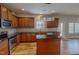 Kitchen featuring wood cabinets, dark countertops, and stainless steel appliances, with an island for extra prep space at 1171 Jackson Ct, Creedmoor, NC 27522