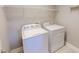 Bright laundry room featuring a full-size white washer and dryer, and shelving for storage at 1171 Jackson Ct, Creedmoor, NC 27522