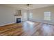 Bright living room features a cozy fireplace, wood-look floors, and a large window at 1171 Jackson Ct, Creedmoor, NC 27522
