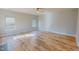 Open living room with wood floors, large windows, and a ceiling fan, offering a bright and airy atmosphere at 1171 Jackson Ct, Creedmoor, NC 27522