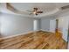 Expansive main bedroom featuring wood-look floors, a tray ceiling, and ceiling fan at 1171 Jackson Ct, Creedmoor, NC 27522