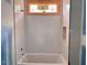 Bathroom tub with window, featuring scallop tile design and modern tub at 1216 Barcroft Pl, Raleigh, NC 27615