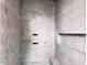 Shower featuring marble tiling, a recessed shelf, and modern fixtures at 1216 Barcroft Pl, Raleigh, NC 27615