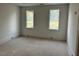 A well-lit bedroom with two windows providing ample natural light and a minimalist aesthetic at 1216 Barcroft Pl, Raleigh, NC 27615