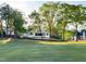Exterior view of a bright white house surrounded by lush green lawn and mature trees at 1216 Barcroft Pl, Raleigh, NC 27615