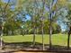Scenic golf course view with lush green grass, mature trees, and a golf cart in the distance at 1216 Barcroft Pl, Raleigh, NC 27615