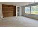 This open living room features a wood accent wall, built in shelves, and lots of natural light at 1216 Barcroft Pl, Raleigh, NC 27615