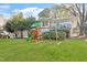 Spacious backyard with a playset, lush green lawn, and mature trees at 1417 Hathaway Rd, Raleigh, NC 27608