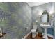 Stylish powder room featuring wallpaper, pedestal sink, and decorative sconces at 1417 Hathaway Rd, Raleigh, NC 27608