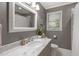 Bathroom featuring a marble vanity, neutral color palette, and modern fixtures at 1417 Hathaway Rd, Raleigh, NC 27608