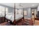 Bedroom featuring a four-poster bed, hardwood floors, and plantation shutters for natural lighting at 1417 Hathaway Rd, Raleigh, NC 27608