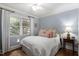 Cozy bedroom with large window, soft colors, plush bedding, and hardwood floors at 1417 Hathaway Rd, Raleigh, NC 27608