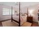 Bedroom featuring a four-poster bed, wood floors, and a cozy, inviting atmosphere at 1417 Hathaway Rd, Raleigh, NC 27608