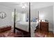Cozy bedroom features a four-poster bed, hardwood floors, and a patterned rug at 1417 Hathaway Rd, Raleigh, NC 27608