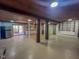 A large basement with white shelving, stainless steel refrigerator, wooden beams and outdoor access at 1481 Country Club Rd, Roxboro, NC 27574