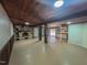 Spacious basement featuring a stone fireplace, wooden support beams, and a built-in cabinet area at 1481 Country Club Rd, Roxboro, NC 27574