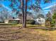 Exterior view showcases a beautiful brick home with a two car garage, set on a large lot with mature trees at 1481 Country Club Rd, Roxboro, NC 27574